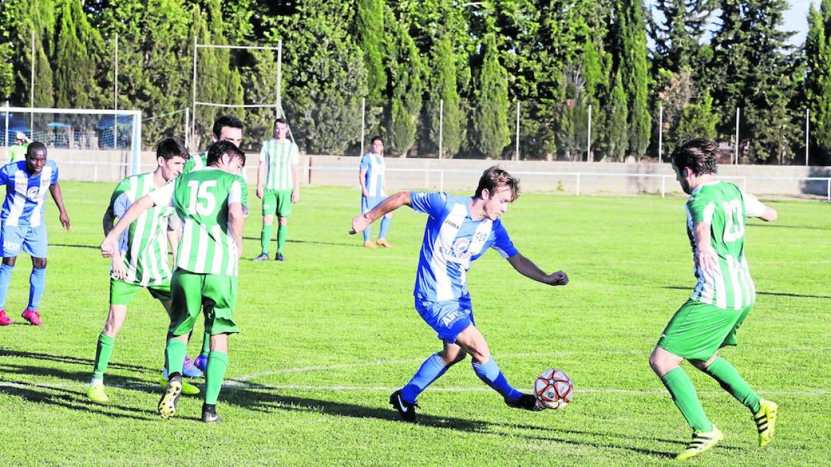 Un jugador del Torregrossa conduce el balón ante la presencia de varios rivales, ayer durante el partido.