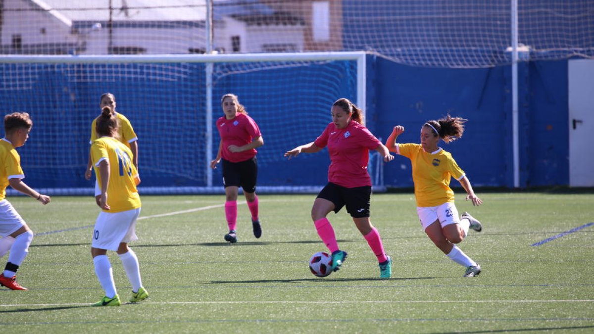 Una jugadora de l’AEM controla la pilota davant de la pressió d’una rival.