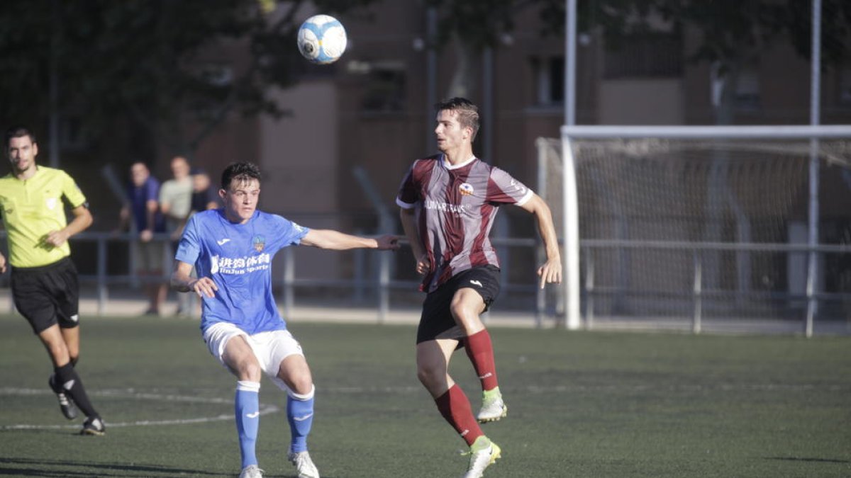 Un jugador del Júpiter es disposa a controlar una pilota, davant de l’oposició d’un altre del Lleida B, ahir durant el partit a Gardeny.