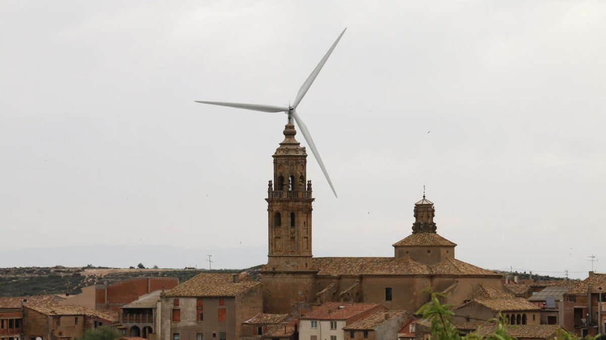 El campanario de La Granadella, con un molino al fondo.