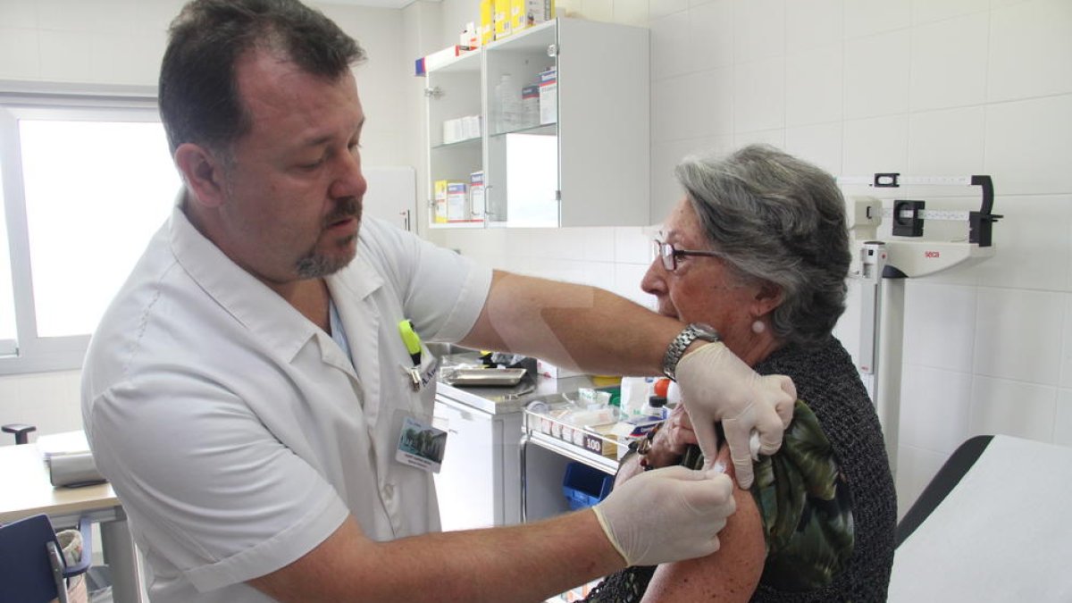 Un enfermero administra la vacuna de a gripe.