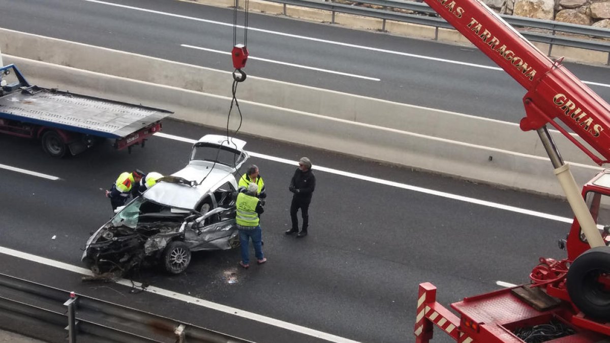 El cotxe, que es va precipitar al buit sobre l'autovia A-7, abans de ser carregat sobre la grua.