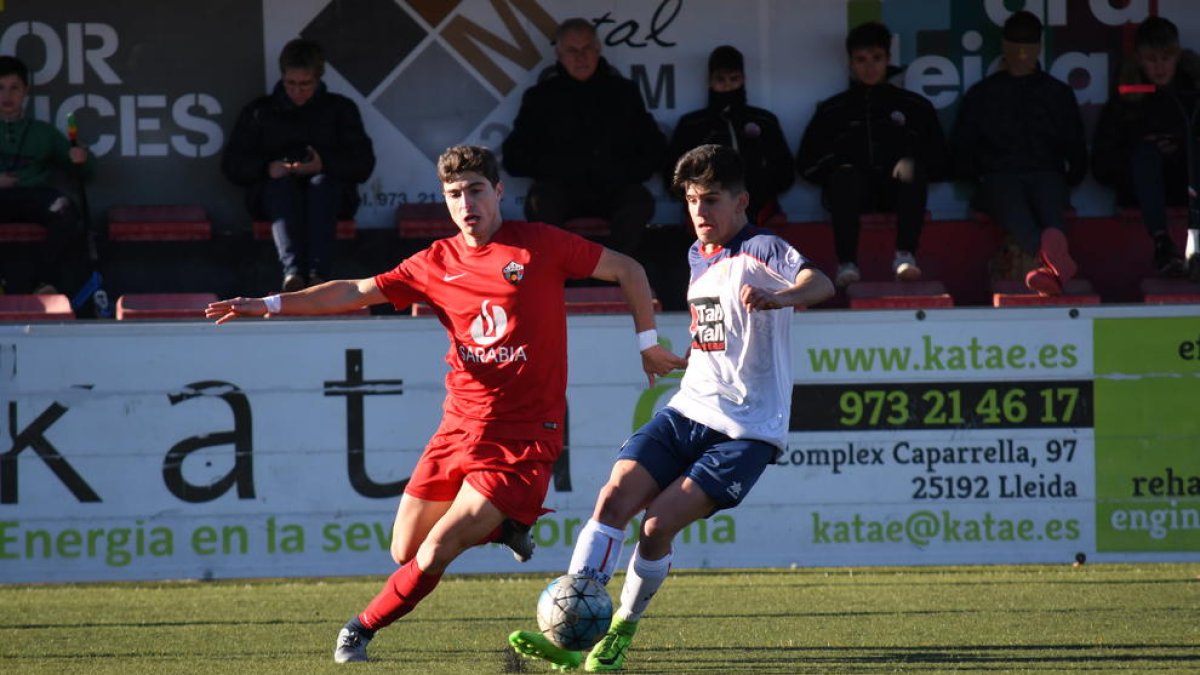 Dos jugadors es disputen una pilota en una jugada del partit que va enfrontar l’Alpicat i el Sant Ildefons.