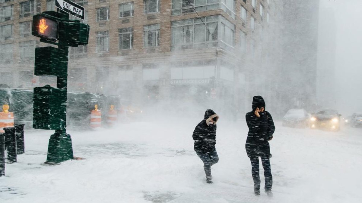 Peatones caminan en plena tormenta de nieve en la ciudad de Nueva York.