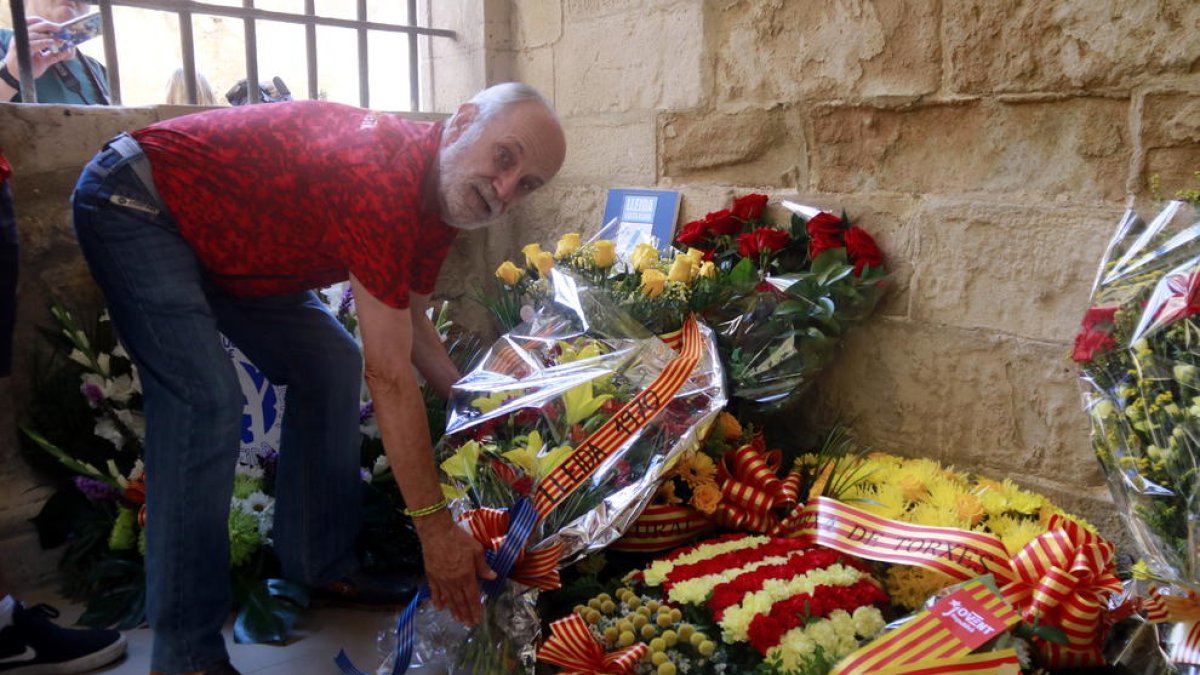 Un membre de la Penya Barcelonista de Lleida diposita l'ofrena floral de la Diada al Roser.