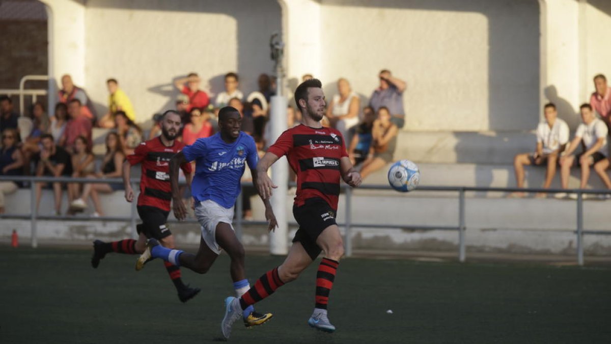 Un jugador del EFAC intenta controlar un balón perseguido por otro del Lleida B.