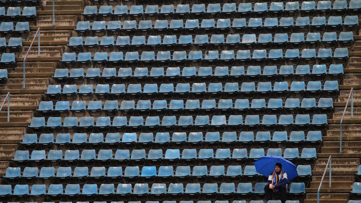 La soledad de un espectador entre tanta grada vacía refleja el aspecto desolado ayer del estadio.