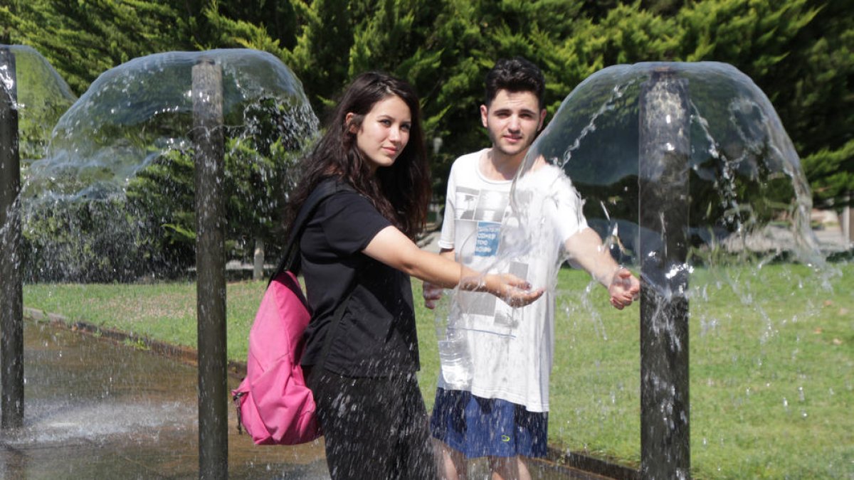 Una pareja de jóvenes se refrescaba ayer en las fuentes del paseo Onze de Setembre de Lleida. 