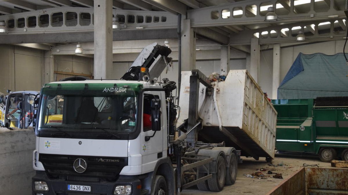 Un camión carga basura en Bellver para trasladarla a Andorra.