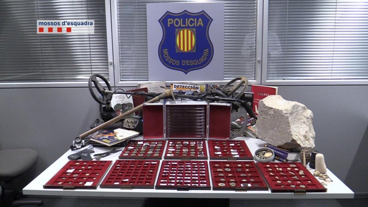 Imagen de las monedas, el detector y otros utensilios encontrados en el domicilio del acusado.