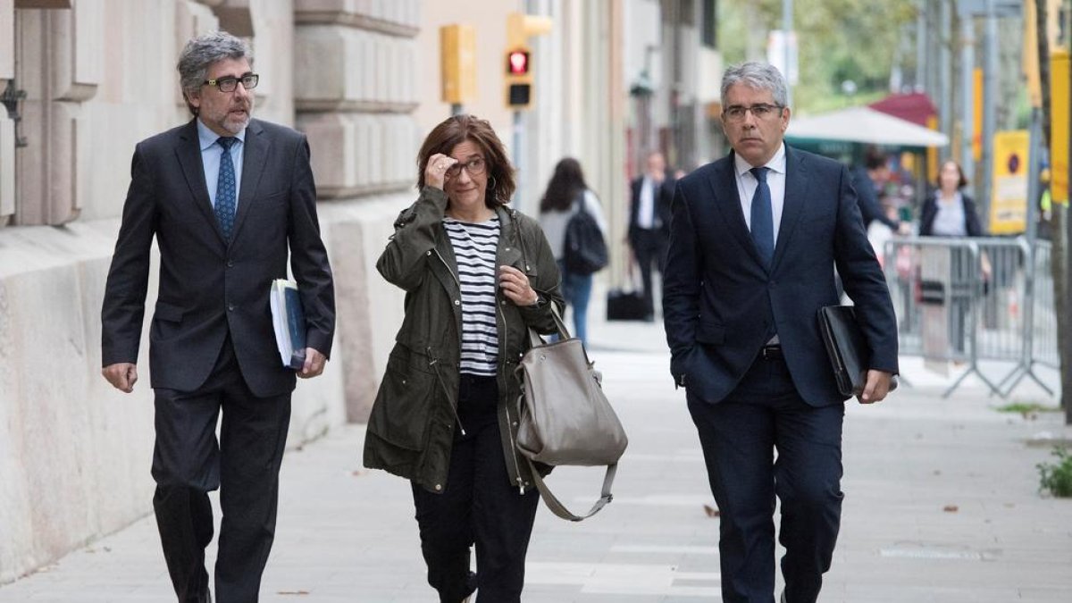 La dona de l'exconseller de Presidència Jordi Turull, Blanca Bragulat, acompanyada del seu advocat Jordi Pina (esquerra) i l'exconseller Francesc Homs, a la seva arribada al Tribunal Superior de Justícia de Catalunya.