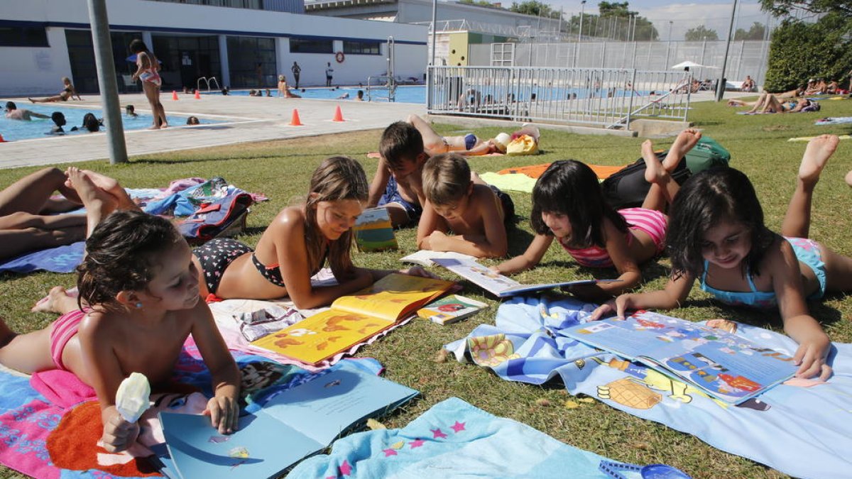 Alguns dels nens que ahir van gaudir de la bibliopiscina de les piscines municipals de Pardinyes, a Lleida.