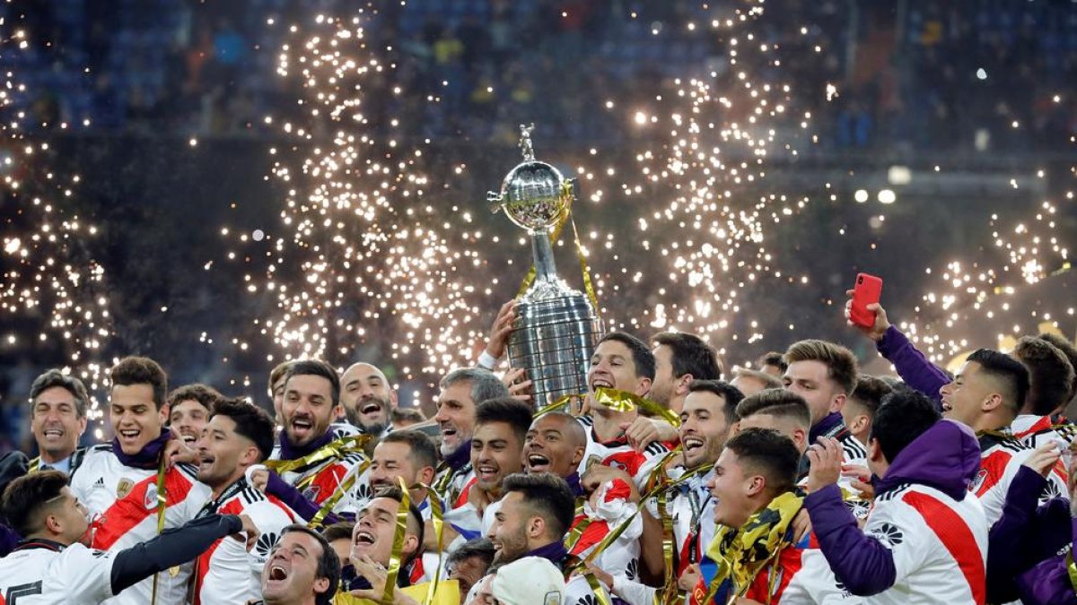 Jugadores y técnicos del River Plate celebran levantando la Copa la conquista del título que les acredita como campeones de Sudamérica.