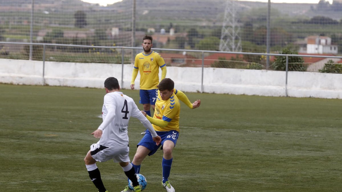 Un jugador del Borges intenta robar la pilota a un del Vila-seca al centre del camp.