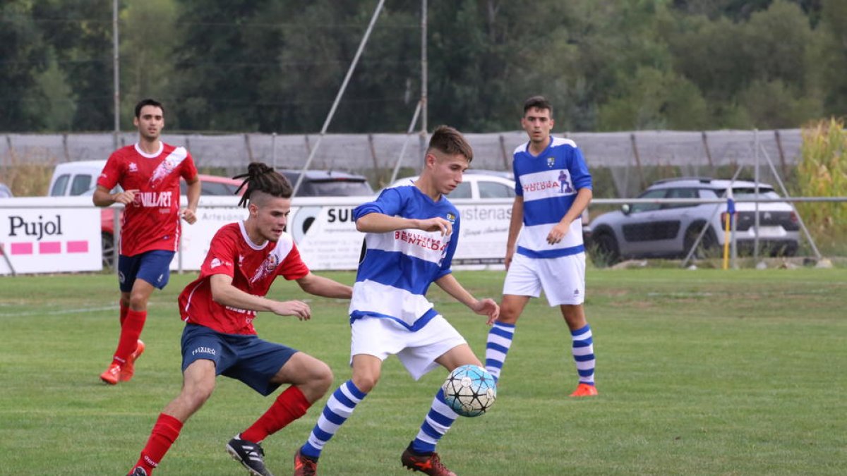 Un jugador del equipo local intenta controlar el balón ante la presión de los visitantes.