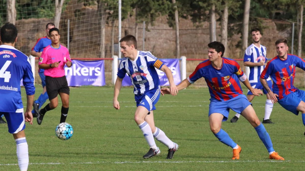 Un futbolista de l’Organyà controla la pilota davant la pressió d’un rival, en una acció del partit d’ahir.