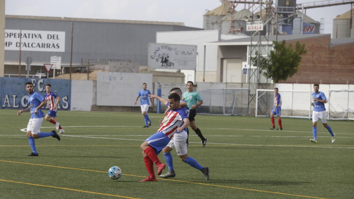 Un jugador del Agramunt intenta contactar con el esférico ante la presión del rival.