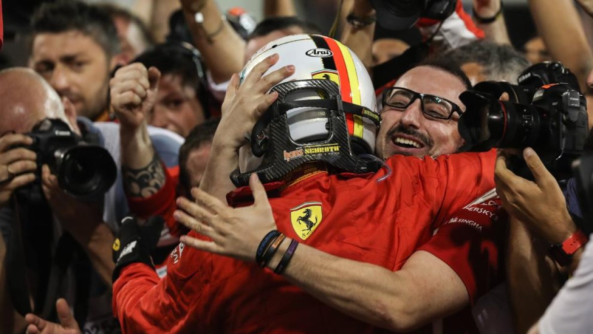 Sebastian Vettel celebra el triunfo en el circuito de Bahrein con uno de sus mecánicos ayer tras la carrera.