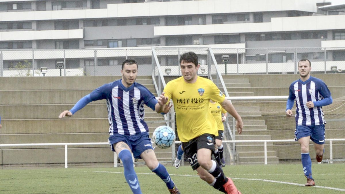 Un jugador del Lleida B amb la pilota controlada intenta anar-se’n per velocitat d’un contrari.