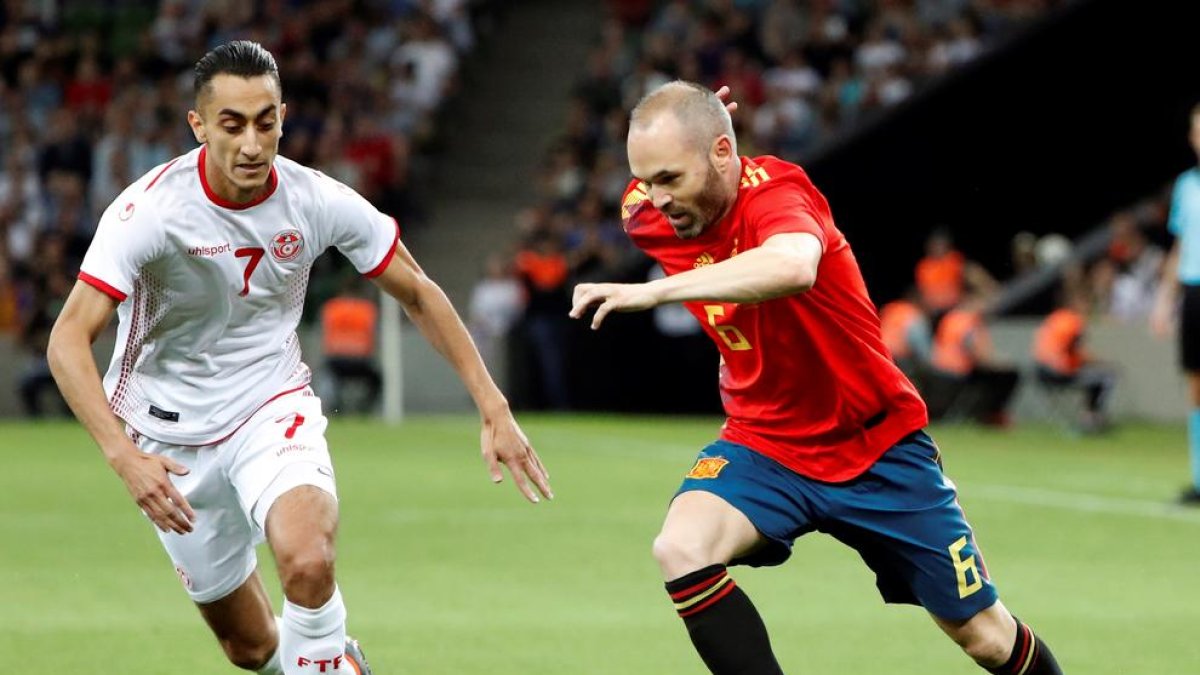 Andrés Iniesta porta la pilota davant de la pressió del jugador de Tunísia, Saif-Eddine Khaoui.