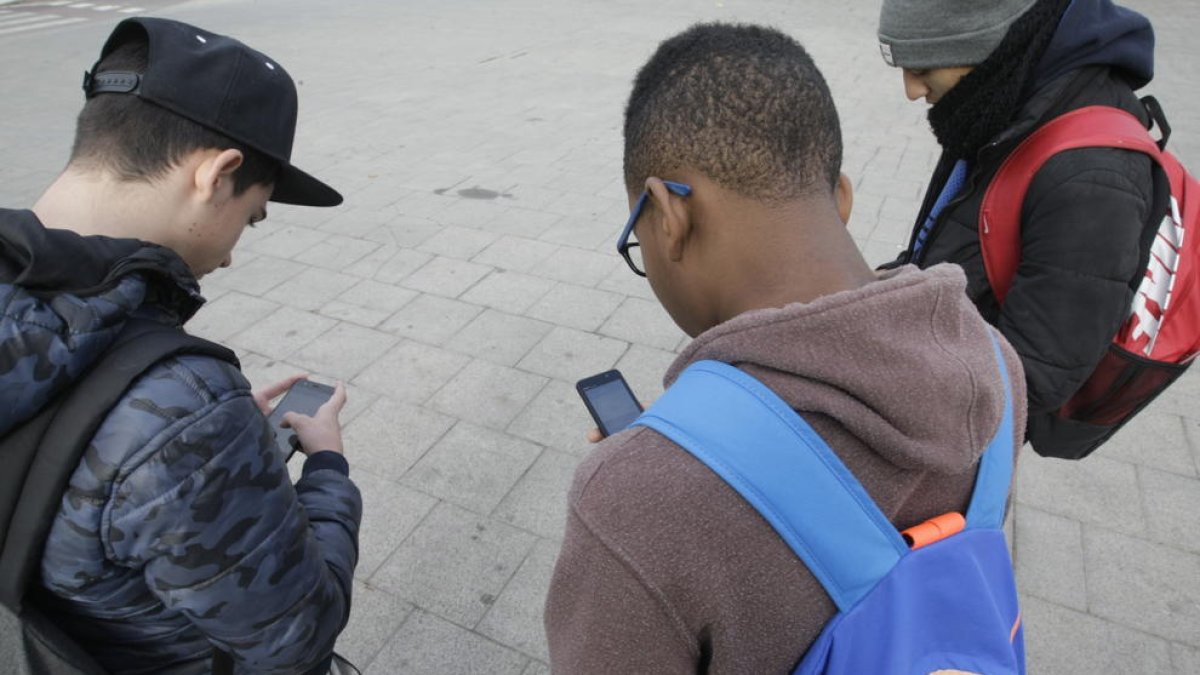 Imagen de archivo de jóvenes utilizando su teléfono móvil. 