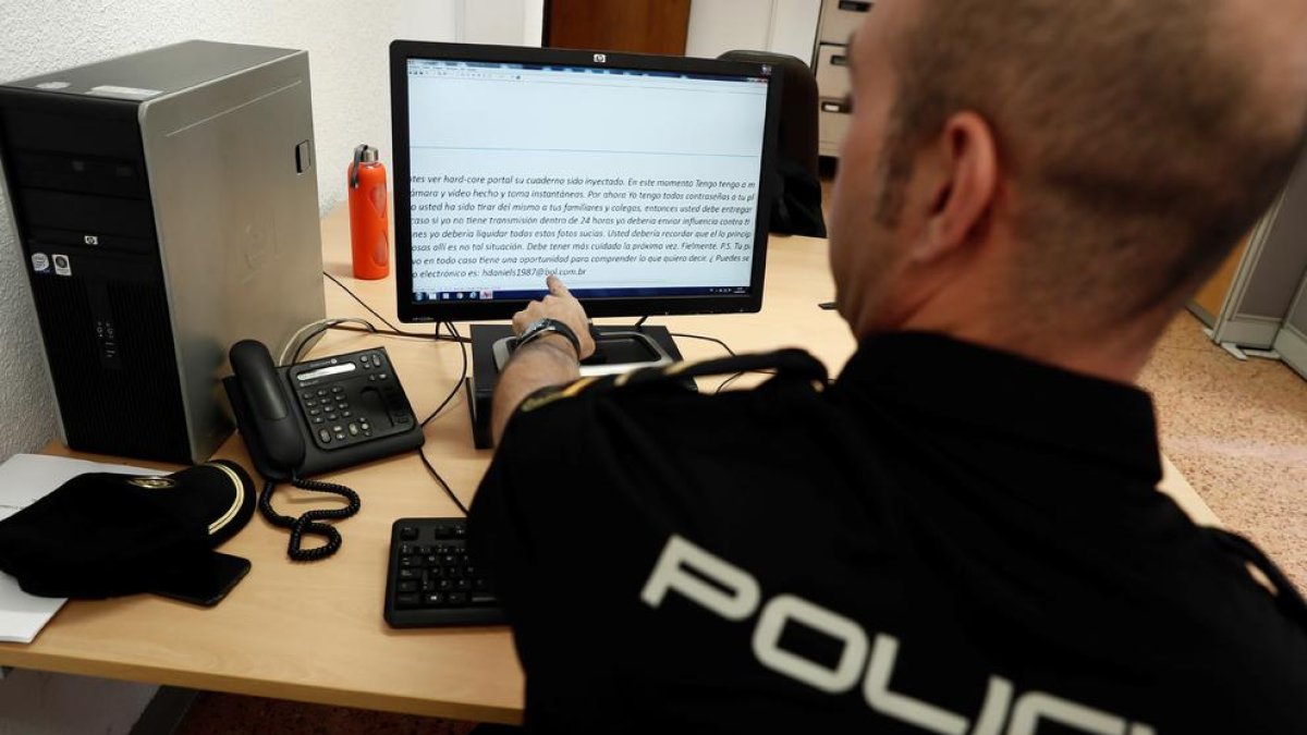 Un agent de la Policia Nacional mostra el correu electrònic que reben les víctimes de l’estafa.