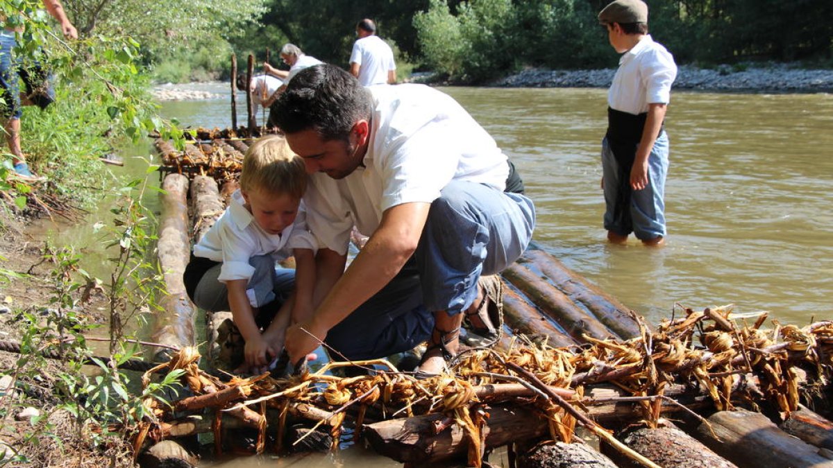 Foto de familia de la veintena de ‘raiers’ que han participado este año en Coll de Nargó en la construcción y la navegación de estas barcas de madera. 