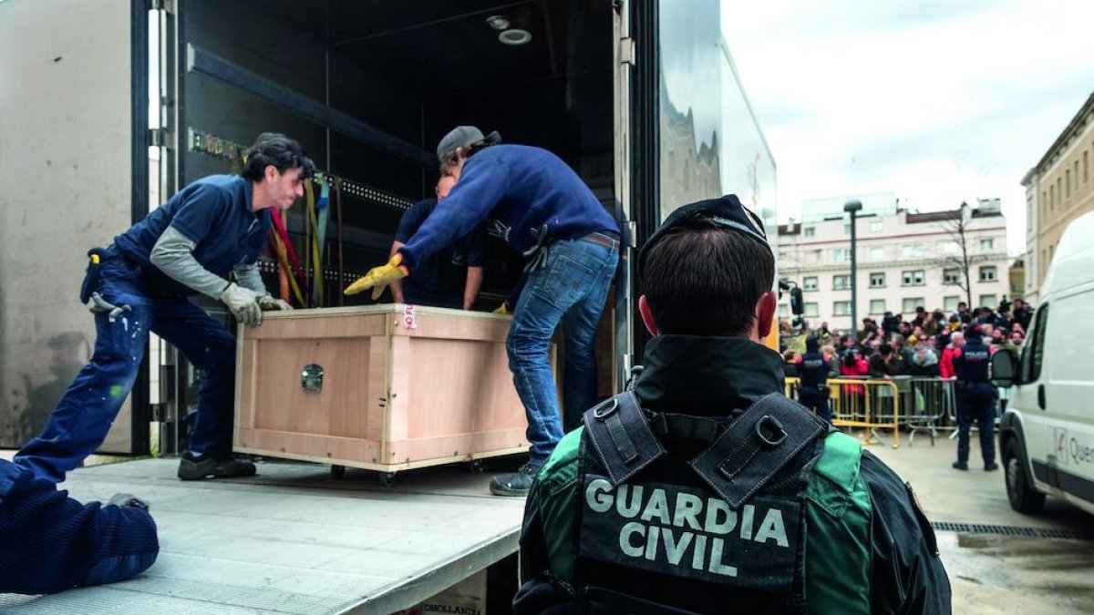 Una de las fotos del libro ‘Operació trasllat. Art de Sixena’, tomada en el interior del Museu durante la operación de traslado del arte, con los técnicos ‘rodeados’ de policía judicial y Guardia Civil.