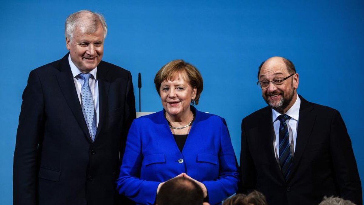 Angela Merkel, ahir, amb el líder de l’SPD, Martin Schulz (dreta), i el de la CSU, Horst Seehofer.