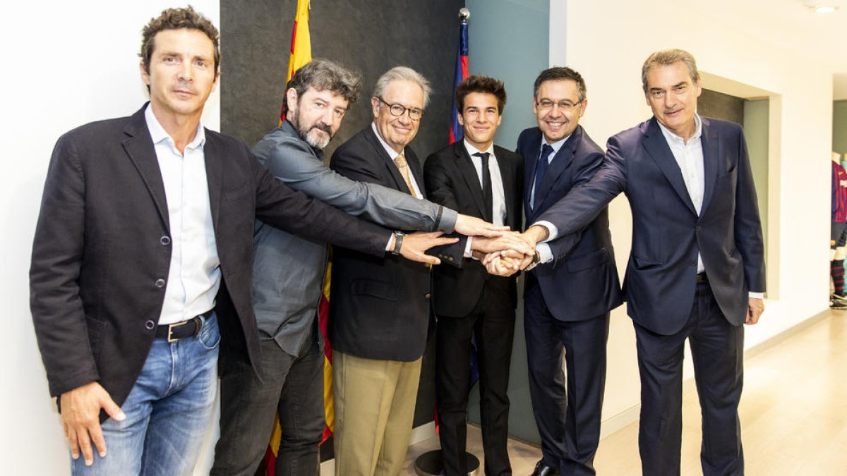 Riqui Puig, al centre, amb els representants del Barça després de firmar la renovació.