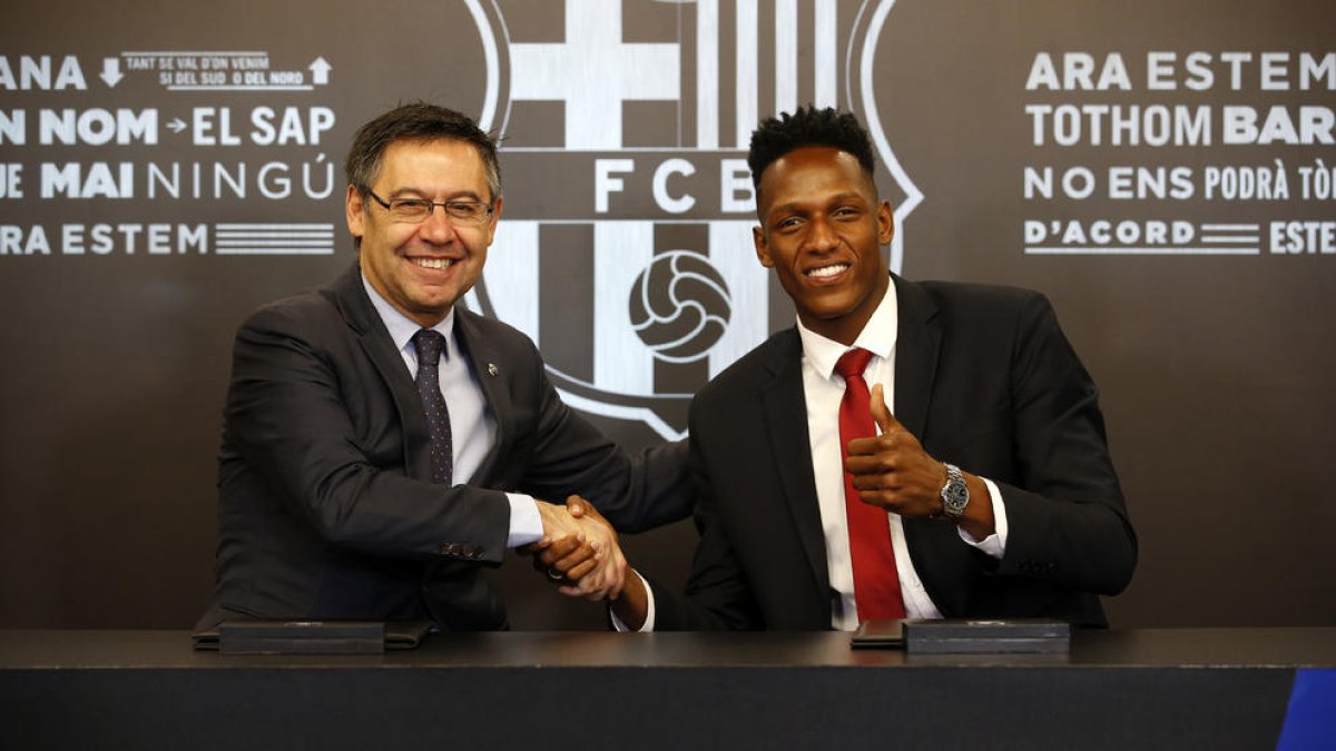 Josep Maria Bartomeu y Yerri Mina ayer durante la firma del contrato.