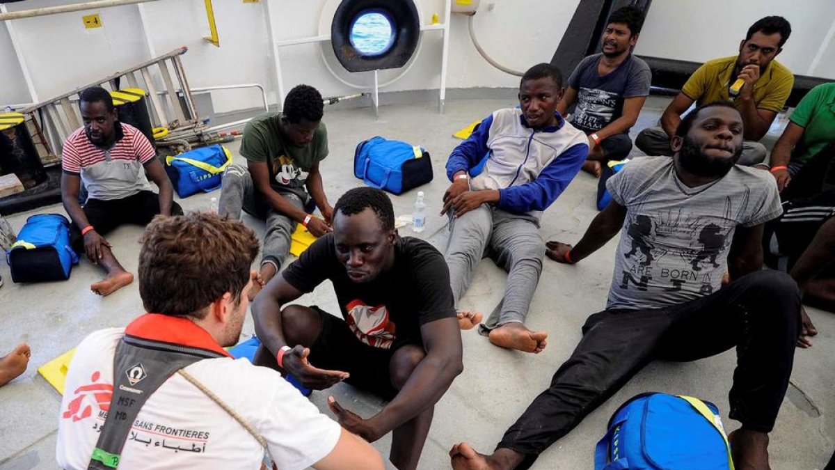 Imatge de migrants amb membres de l’equip de Metges sense Fronteres.