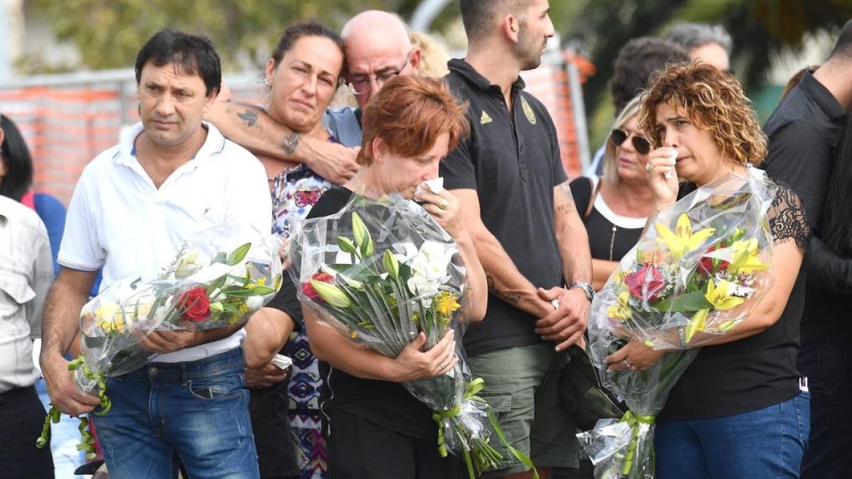 Familiars de les víctimes porten flors durant l’homenatge a Gènova.