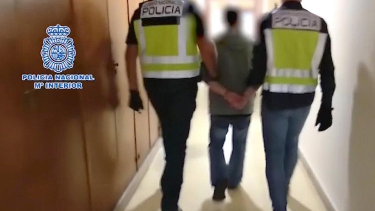 Imagen de dos agentes acompañando a César Román en su detención, ayer.