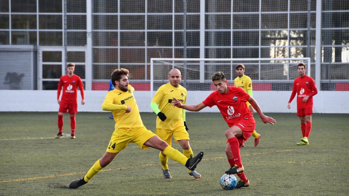 Un jugador de l’Alpicat mira de retallar davant la pressió de diversos rivals.