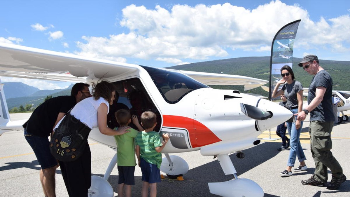 Visitants a l’aeroport de la Seu observen l’interior d’una avioneta ultralleugera.