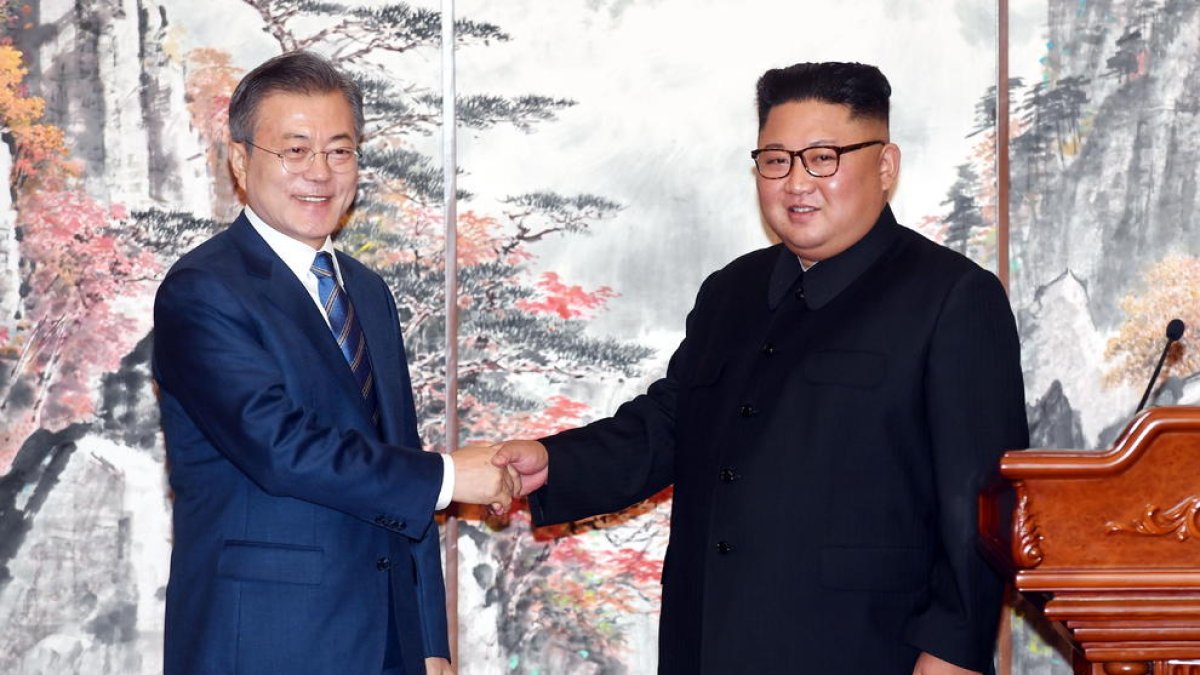 Kim Jong-un (d), dando la mano al presidente surcoreano, Jae-in (i).