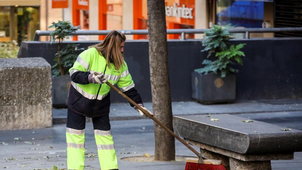 Una treballadora neteja el carrer.