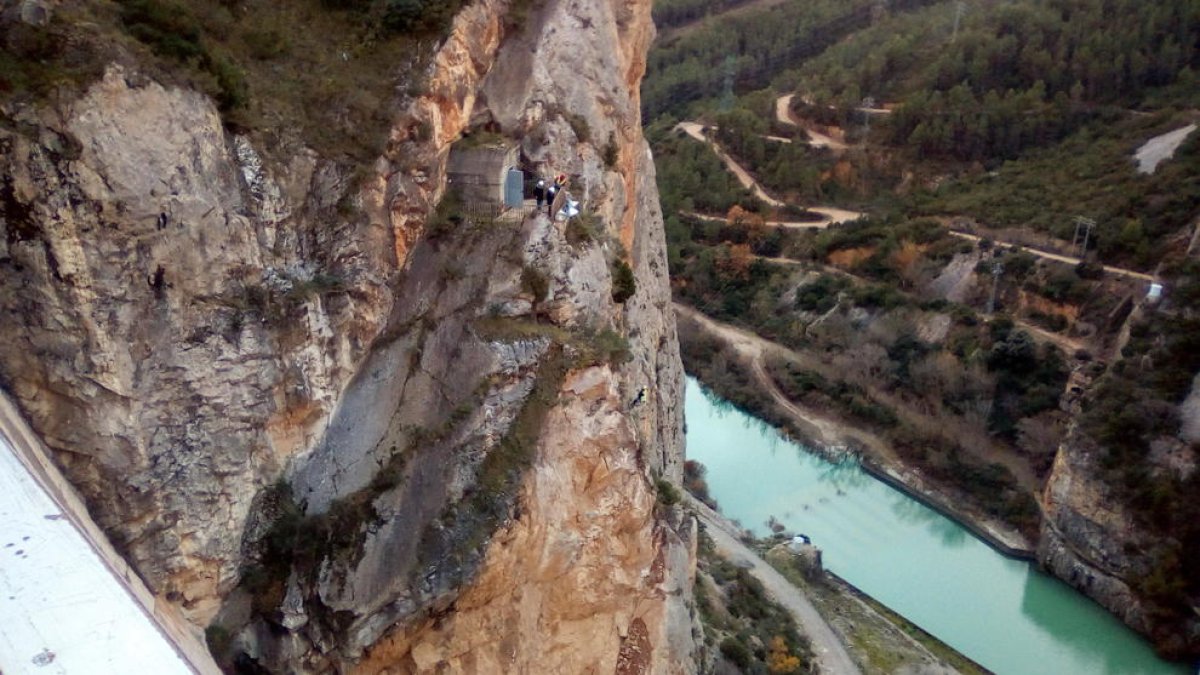 Operaris inspeccionen el pendent pròxim a la presa de Canelles.