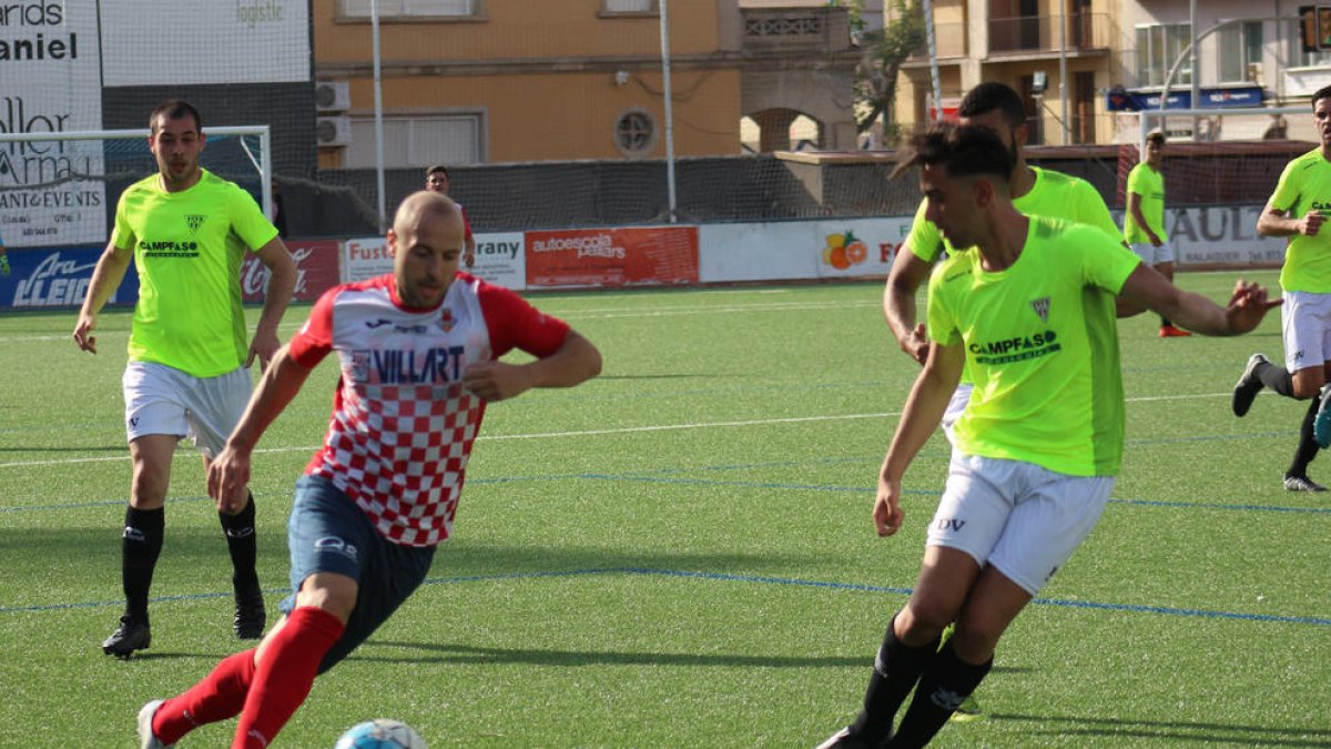 Adrià, con el balón controlado, encara a un jugador del Viladecans, con otros dos rivales atentos al balón.