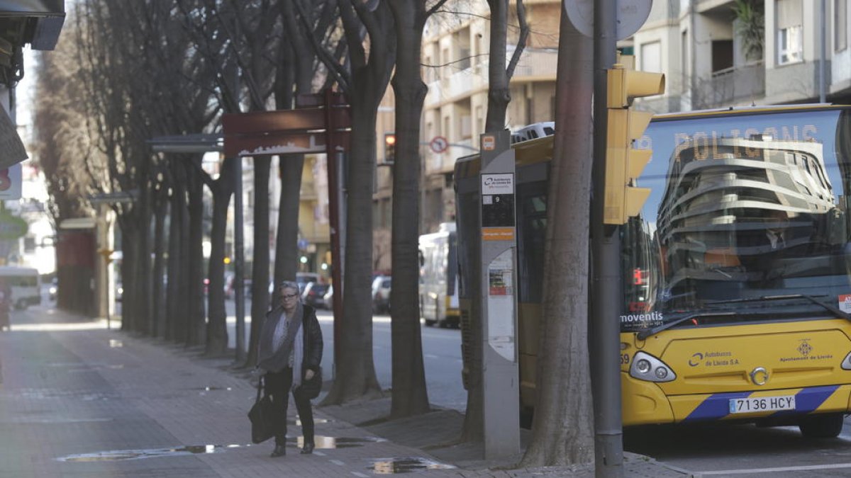 Una usuaria del autobús baja cruzando el carril bici.