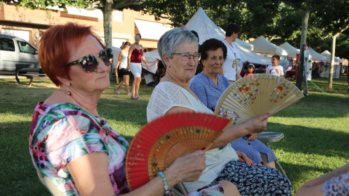 Un grup de dones miren d’evitar la intensa calor amb vanos.