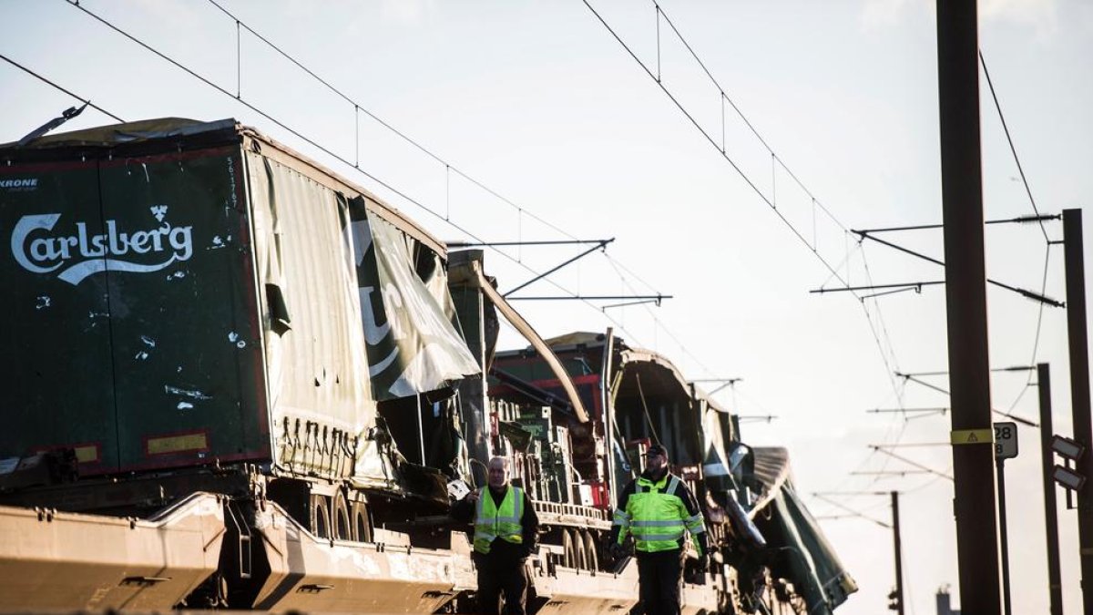 Diversos operaris passen pel costat d’un tren de càrrega al pont de Gran Belt.