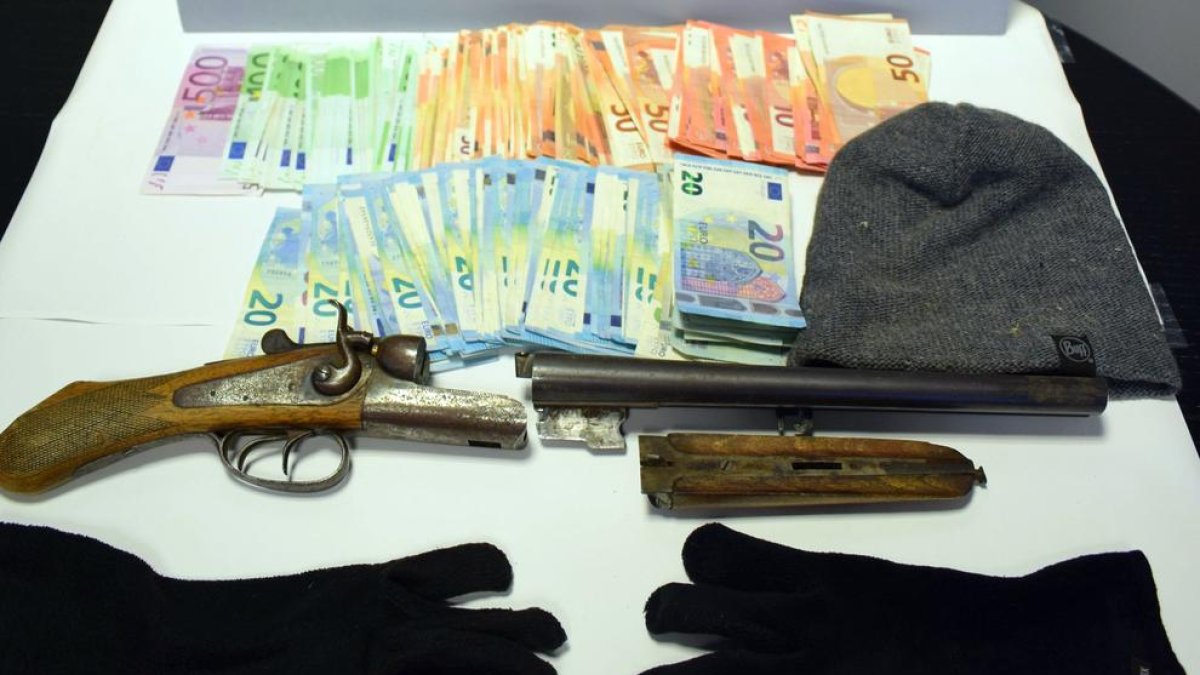 Imatge dels diners robats i l’escopeta, passamuntanyes i guants que portava l’atracador.