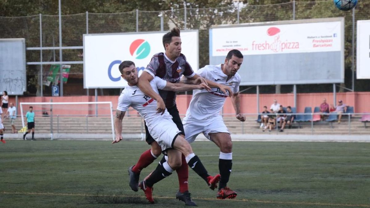 Dos jugadors del Borges intenten frenar l’avanç d’un rival del Júpiter.