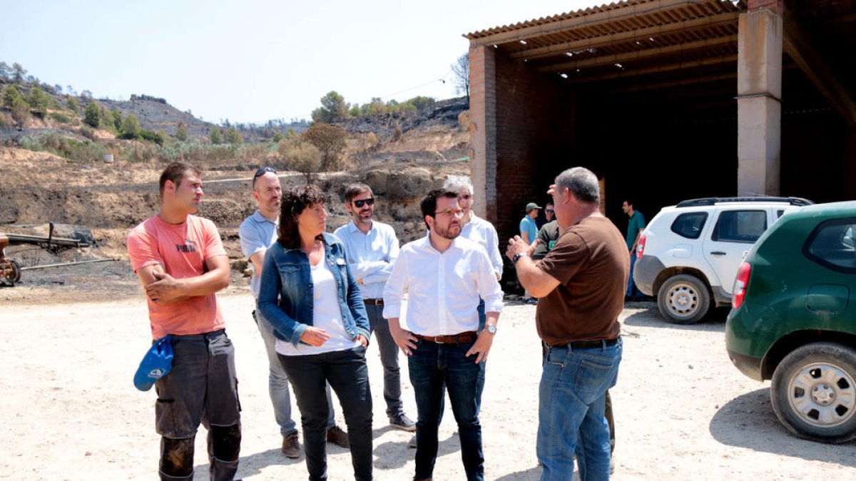 El vicepresidente del Govern, Pere Aragonès, y la consellera de Agricultura, Teresa Jordà, hablan con el propietario de una granja afectada por el incendio.