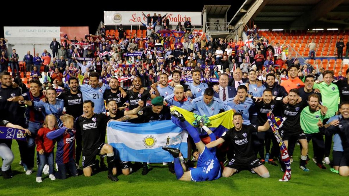 Jugadors i aficionats de l’Osca desplaçats a Lugo per animar l’equip celebren l’ascens.