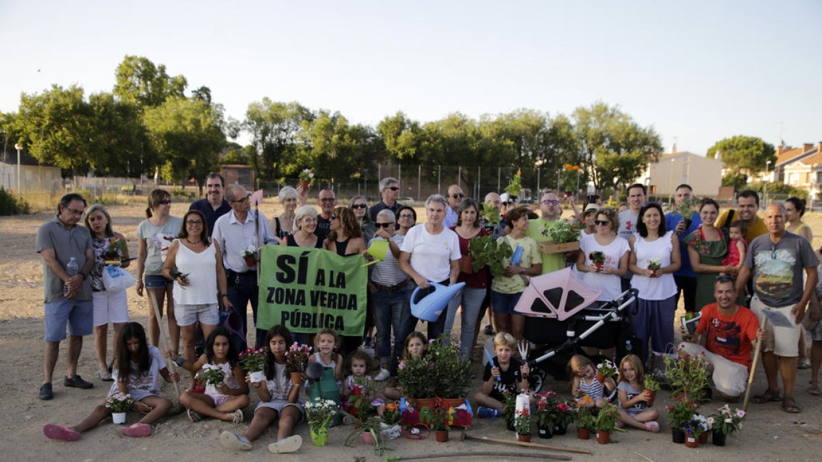 Decenas de vecinos participaron ayer en una plantada de flores en Ciutat Jardí. 