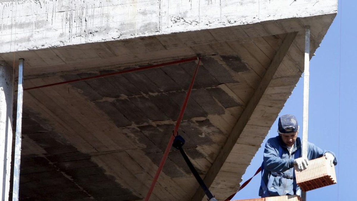 Imatge d’un treballador en la construcció d’un bloc d’habitatges.