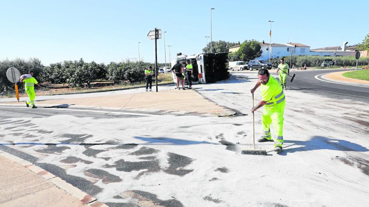 Operarios tiraron arena sobre la carretera para que absorbiera el gasoil de la cuba, volcada en el fondo de la imagen. 